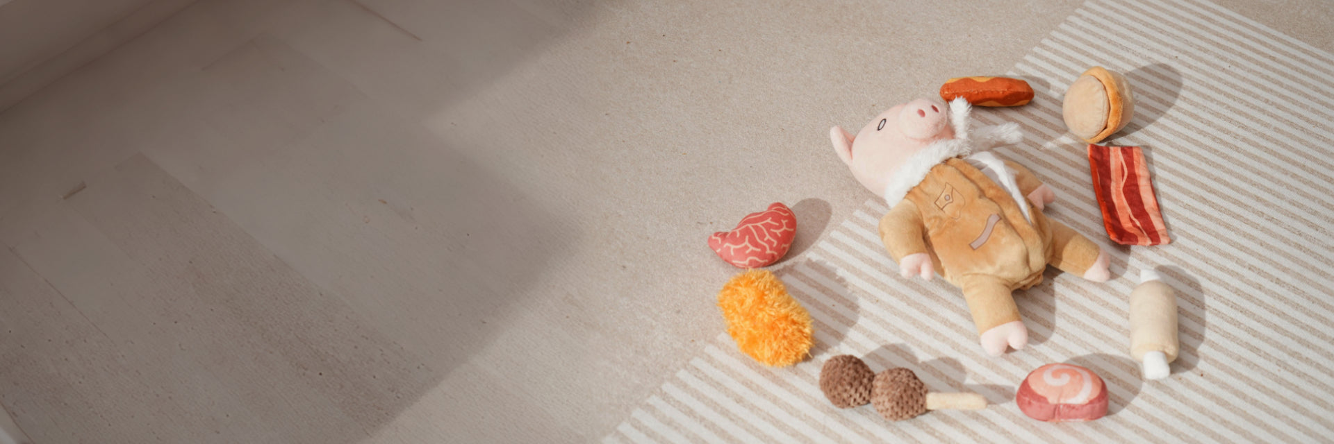 New Toys including a soft pig plush and various play food items for dogs on a striped rug.